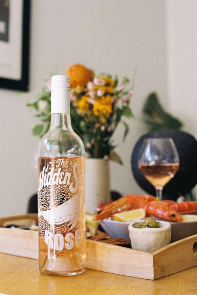 Bottle of Hidden Sea rose wine next to a table full of food