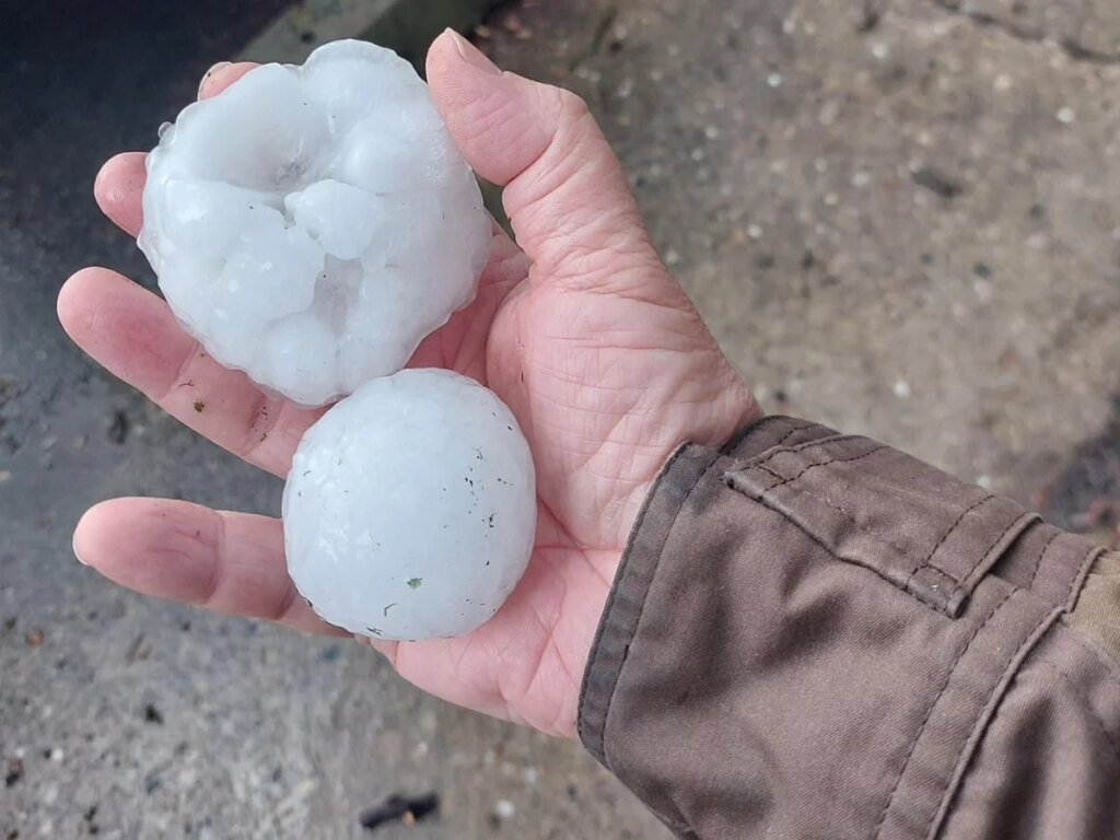 Photo of two baseball size hail in a man's hand